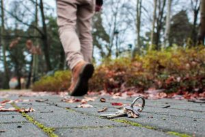 Man's legs walking away as house keys lie on the ground -- marital abandonment can be cited as grounds for divorce.